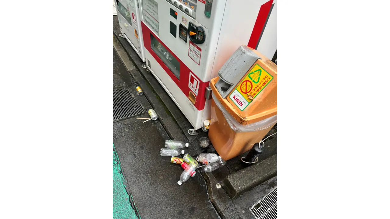 自動販売機とごみ箱のそばに散らばるペットボトル